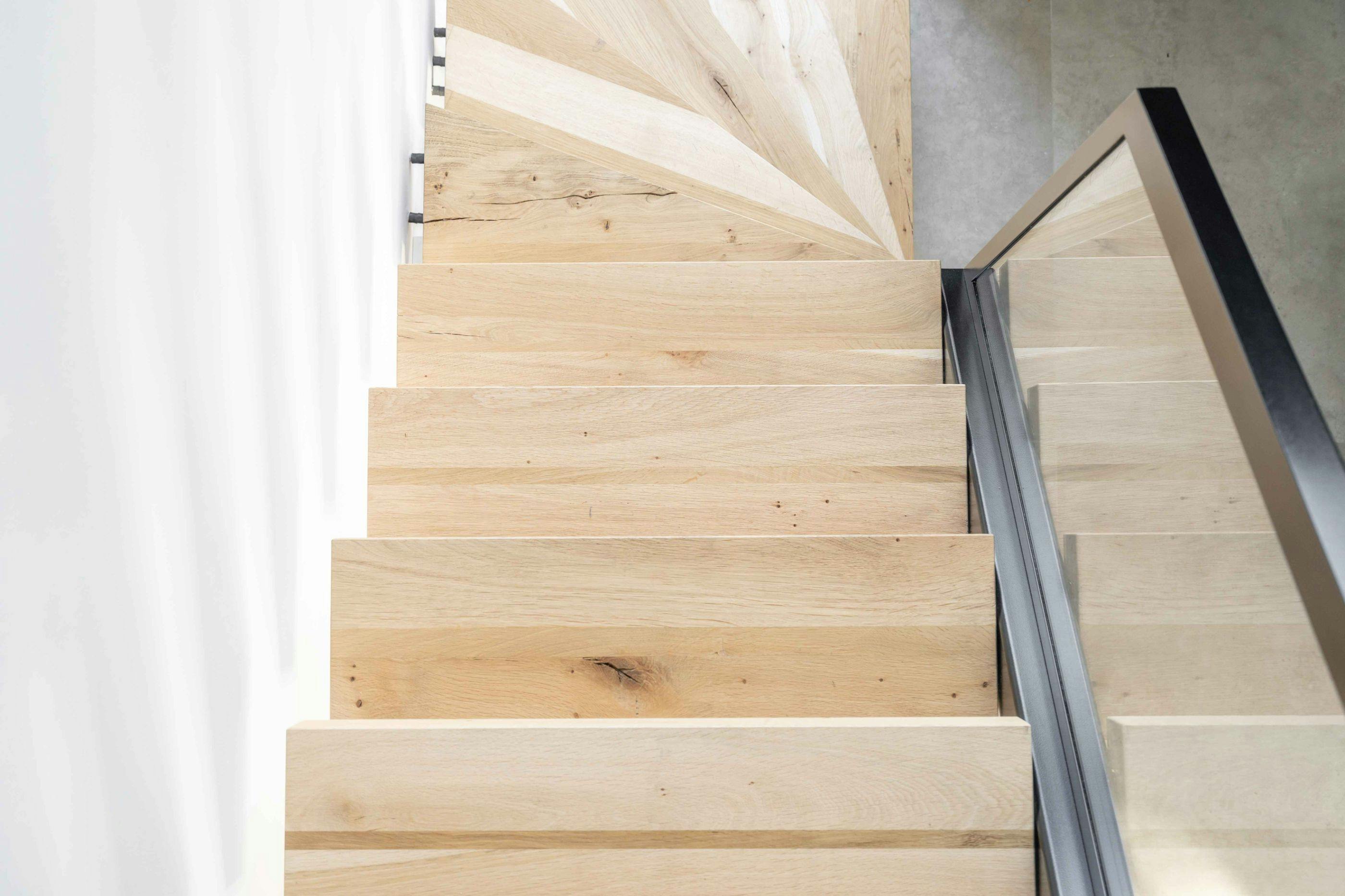 Stalen zwevende trap met massief eiken houten treden 